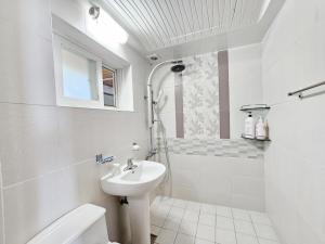 a white bathroom with a shower and a sink at Long Beach Pension in Seogwipo +44 photos