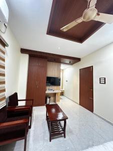 a living room with a ceiling fan and a table at S Hotel Neela in Musiri