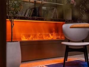 a fireside bar with a chair and a fireplace at Mercure Pingyao Ancient City in Pingyao