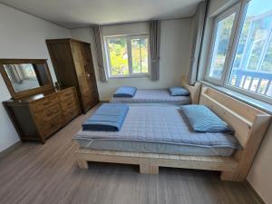 two beds in a room with two windows at Herkules Namhae German Village in Namhae