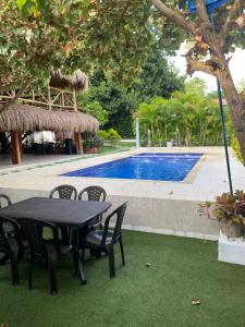 a black table and chairs next to a swimming pool at Dream Country Cabin in Cañaveral