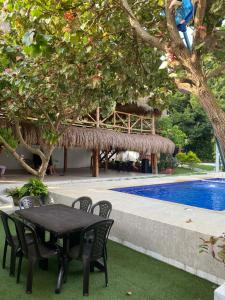 a table and chairs next to a swimming pool at Dream Country Cabin in Cañaveral