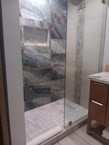 a shower with a glass door in a bathroom at Cali inn in Anaheim