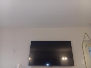 a flat screen tv hanging on a white wall at Cali inn in Anaheim