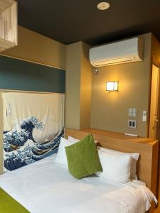 a bedroom with a bed with a painting of a wave at Suzuran Tengachaya 鈴蘭天下茶屋 - 45min to Kansai Airport, Tengachaya Sta 8min in Osaka