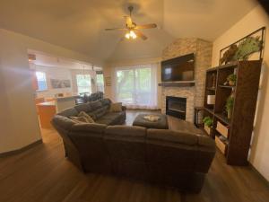 a living room with a brown couch and a fireplace at Delaware Springs Home in Burnet