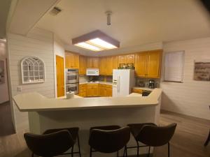 a kitchen with wooden cabinets and a white refrigerator at Delaware Springs Home in Burnet +4 photos