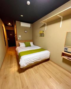 a small bedroom with a bed and a television at Suzuran Tengachaya 鈴蘭天下茶屋 - 45min to Kansai Airport, Tengachaya Sta 8min in Osaka