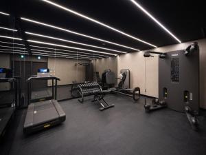 a gym with cardio equipment in a room at Lomä Central Peaks in Shinano