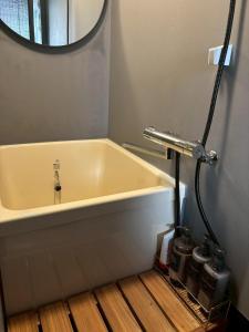 a bath tub in a bathroom with a mirror at 旅籠小龍 in Kochi
