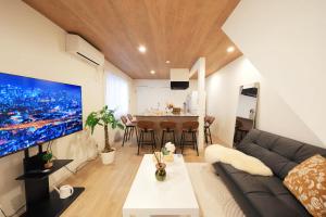 a living room with a couch and a large tv at 愉楽の宿 一棟貸切Villa in Osaka