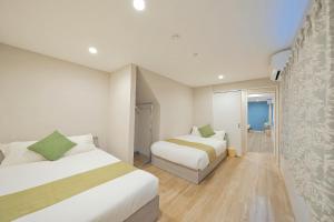 a hotel room with two beds and a hallway at 愉楽の宿 一棟貸切Villa in Osaka