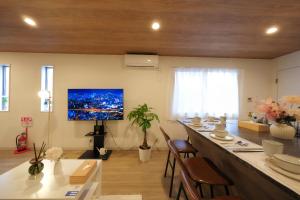 a living room with a long bar with a television on the wall at 愉楽の宿 一棟貸切Villa in Osaka
