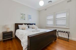 a bedroom with a large bed with a wooden floor at Barkly Cottage Bendigo in Bendigo
