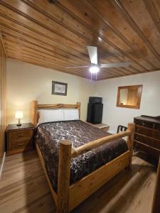 a bedroom with a bed with a wooden ceiling at Dawson House Lodge in Chemult