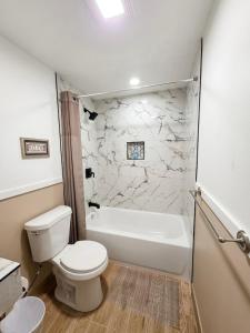 a bathroom with a toilet and a tub and a sink at Dawson House Lodge in Chemult +29 photos