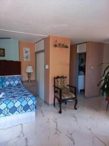 a bedroom with a bed and a chair at Towers by the Beach in Ocho Rios +31 photos