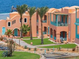 a house with palm trees in front of the ocean at Swissotel Resort El Quseir in Quseir