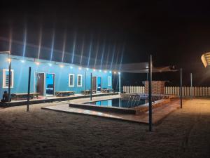 a blue building with a swimming pool at night at D'Biru Guest Room in Melur