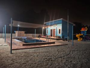 a playground at night with a house and a pool at D'Biru Guest Room in Melur +1 photo