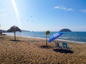 two chairs and an umbrella on a beach at Le Colibri - 1 Min Beach - Pool - Serenity in La Peñita de Jaltemba +18 photos
