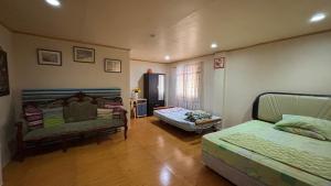 a room with two beds and a couch in it at Buku island in san juan la union