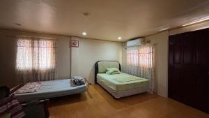 a small room with two beds and two windows at Buku island in san juan la union