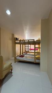 a room with two bunk beds and a chair at Buku island in san juan la union +2 photos