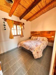 a bedroom with a bed in a room with a window at Al Pie del Pucara in Tilcara