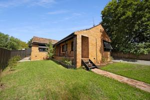 a brick house with a yard in front of it at The Ironbark Nest in Bendigo