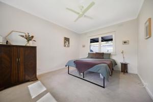 a bedroom with a bed and a ceiling fan at The Ironbark Nest in Bendigo