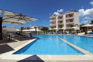 a swimming pool with a hotel in the background at Hotel Beach Restaurant Fabio in Borsh