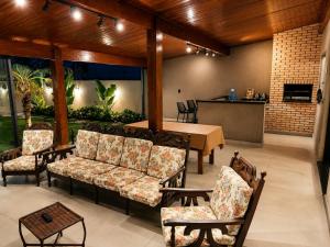 a patio with couches and a table and chairs at Casa Aconchegante com Espaço Gourmet in Itatiba