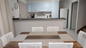 a kitchen with a wooden table and white cabinets at The Goose Ponds in North Mackay