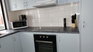 a kitchen with a black oven and a microwave at The Goose Ponds in North Mackay