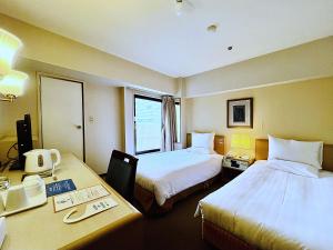 a hotel room with two beds and a desk at Hotel The Centre Utsunomiya in Utsunomiya +94 photos