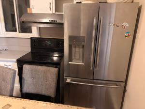 a kitchen with a stainless steel refrigerator and a stove at Oshawa Duplex in Oshawa