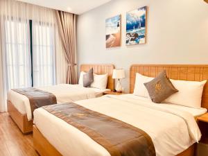 a hotel room with two beds and a window at KB Villas 51 in Bình Tú
