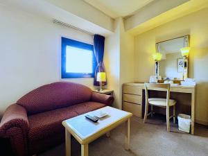 a living room with a couch and a table at Hotel The Centre Utsunomiya in Utsunomiya