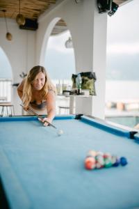 a woman playing a game of pool on a pool table at Lushy Kintamani in Kubupenlokan