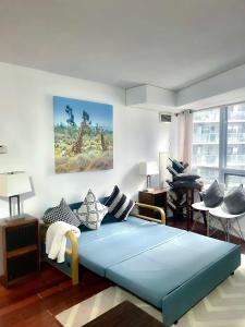 a bedroom with a large blue bed and a living room at Core Downtown Toronto-8 Sleeper-4 Beds-2 Bathrooms-Washrooms-Free Parking-CN Tower-Ripleys Museum-Blue Jays Stadium In front-Indoor Gym-Swimming Pool-Jacuzzi Sauna-Filter Drinking Water-WiFi in Toronto