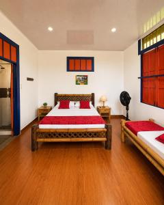 a bedroom with two beds and wooden floors at Finca Hotel Estrella del Eden in Armenia +16 photos