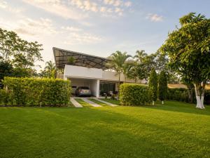 a house with a lawn in front of it at Finca Hotel Estrella del Eden in Armenia