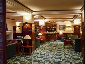a lobby of a hotel with chairs and a bar at Mercure Andorra in Andorra la Vella