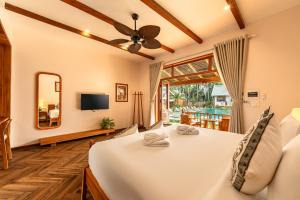 a room with a bed with a mirror and a tv at The Jam Boutique Hotel in Luang Prabang