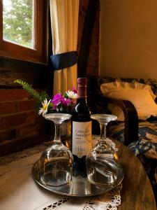 a bottle of wine and two glasses on a table at Chalet Ojo de Agua in Jilotepec de Abasolo