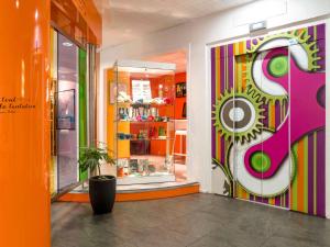 a store with a colorful wall with a window at ibis Styles Besançon in Besançon