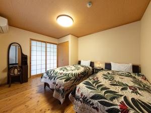 a hotel room with two beds and a mirror at Yufuin Onsen 8A1 Yaeichi in Yufu