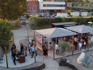 a group of people standing under umbrellas at a restaurant at Novotel Reims Tinqueux in Reims