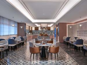 a restaurant with tables and chairs and a bar at Novotel Hangzhou Binjiang in Hangzhou